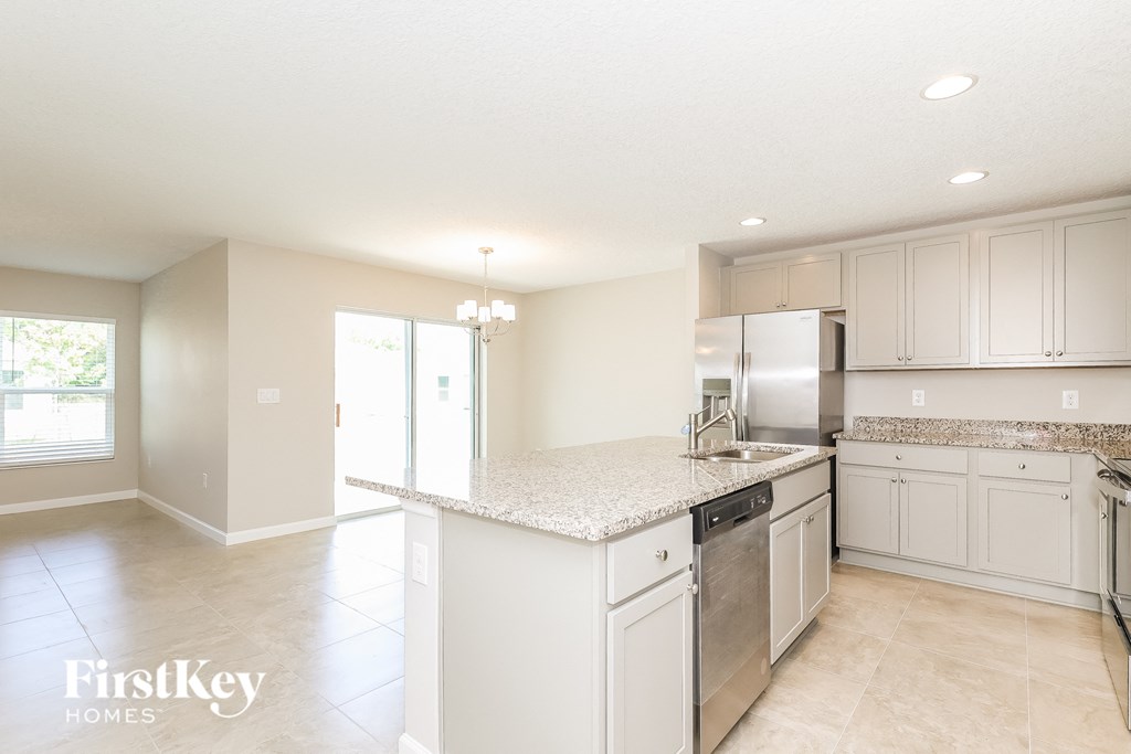 A kitchen with white cabinets and appliances.