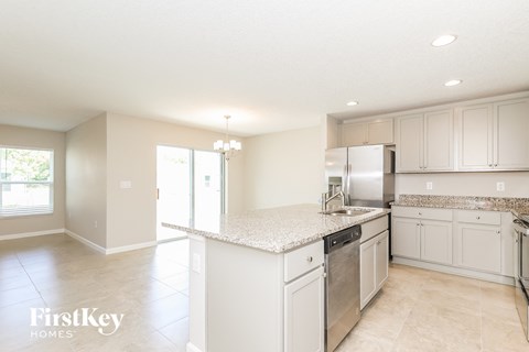 A kitchen with white cabinets and appliances.