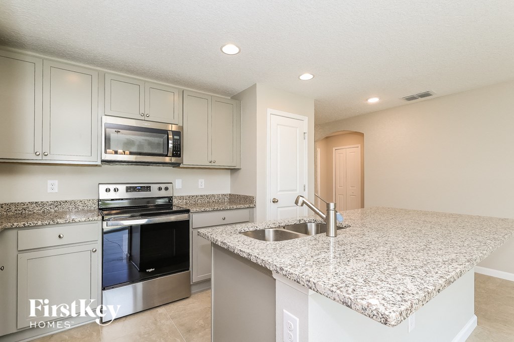 A kitchen with granite countertops and stainless steel appliances.