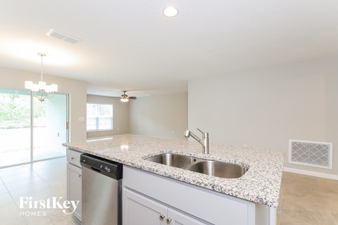 A kitchen with granite countertops and a stainless steel dishwasher.