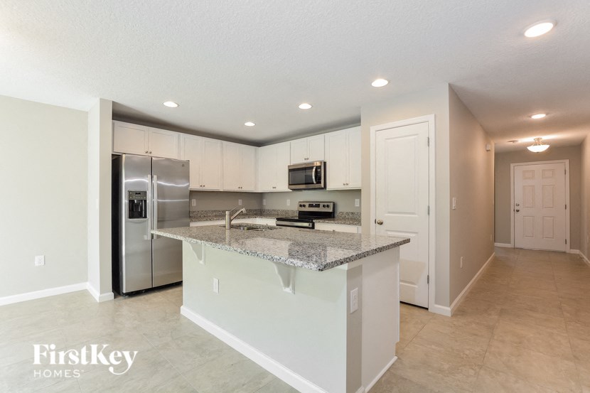 a kitchen with an island and a stainless steel refrigerator