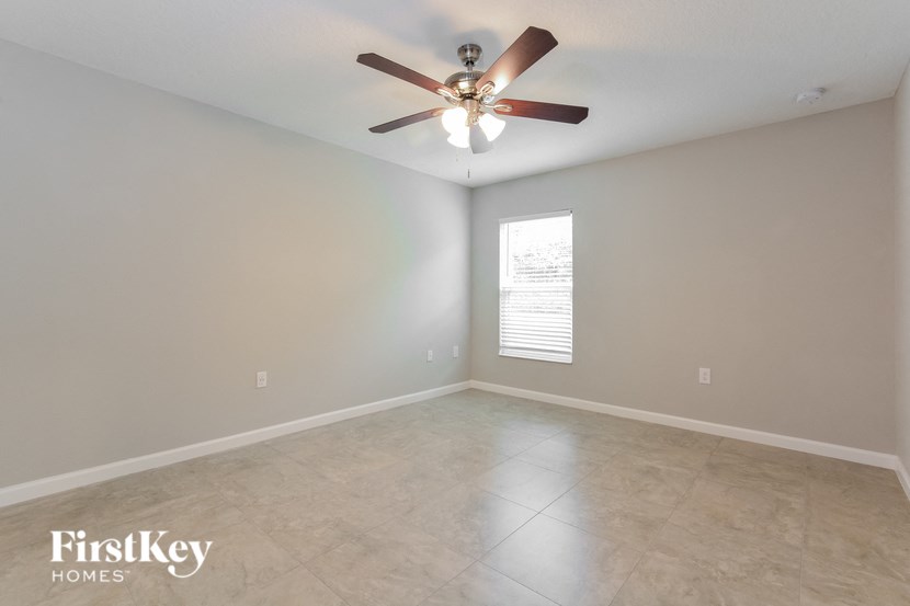 the living room has a ceiling fan and tile flooring