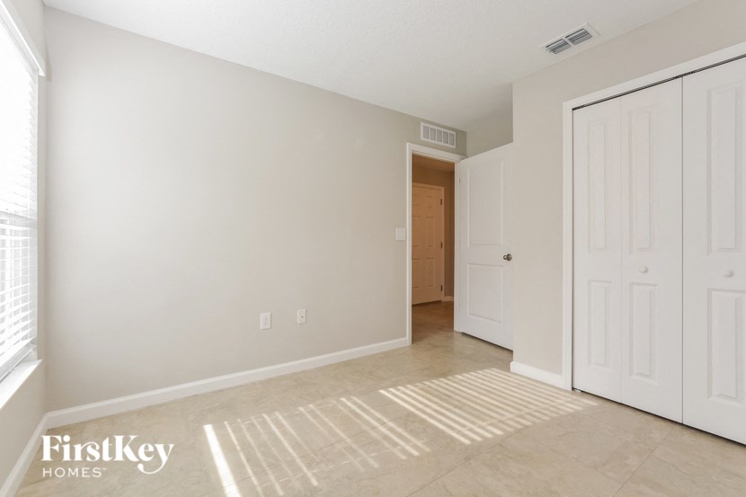 a living room with a door to a hallway and a door into a bedroom