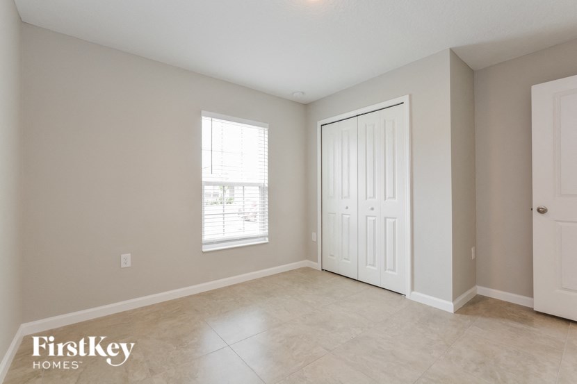 the living room of an empty house with a door and a window