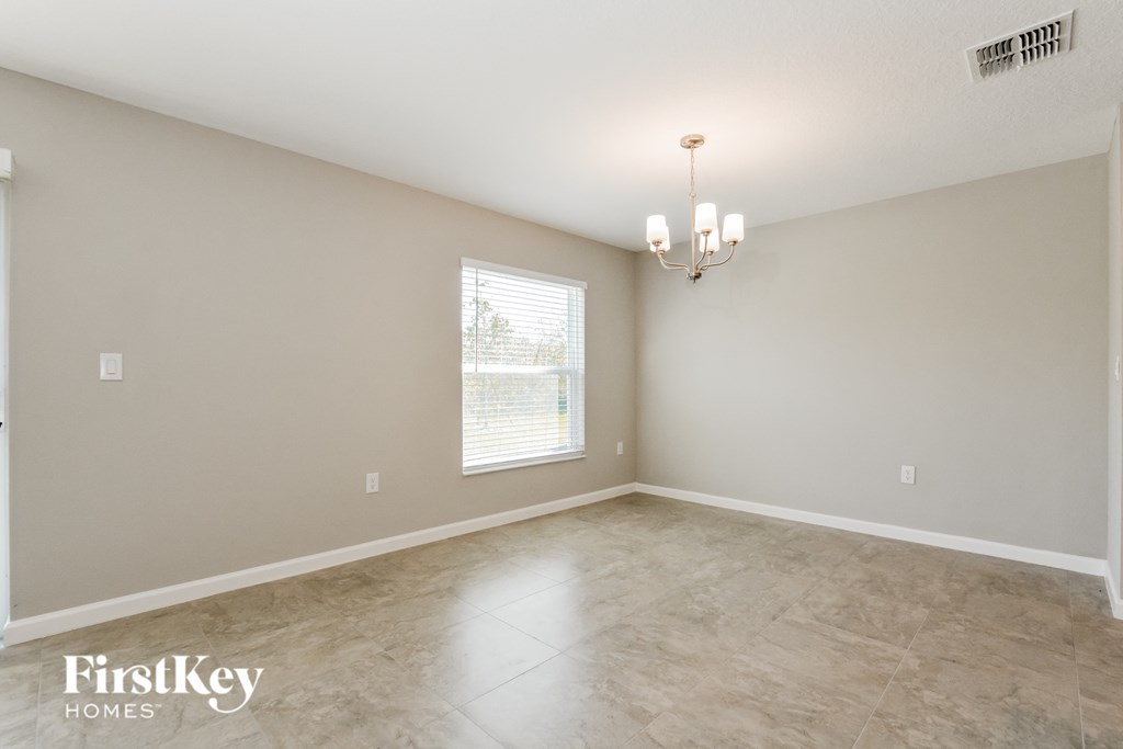 the spacious living room with limestone floors and a window