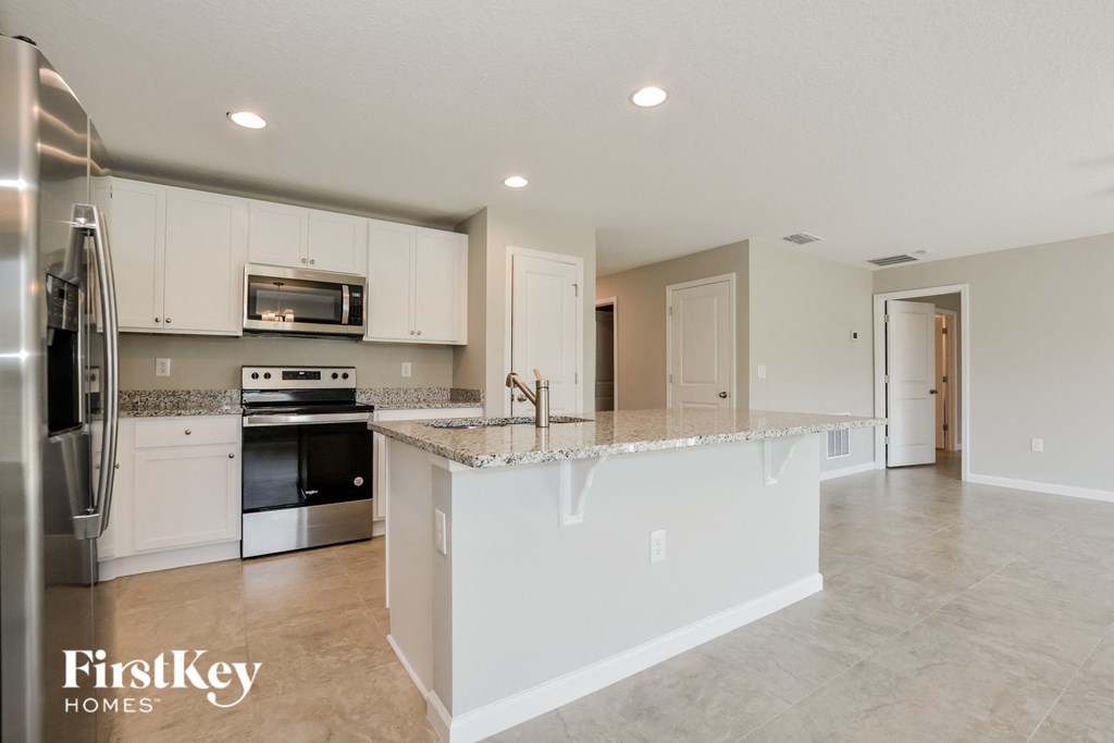 a large kitchen with white cabinets and a counter top
