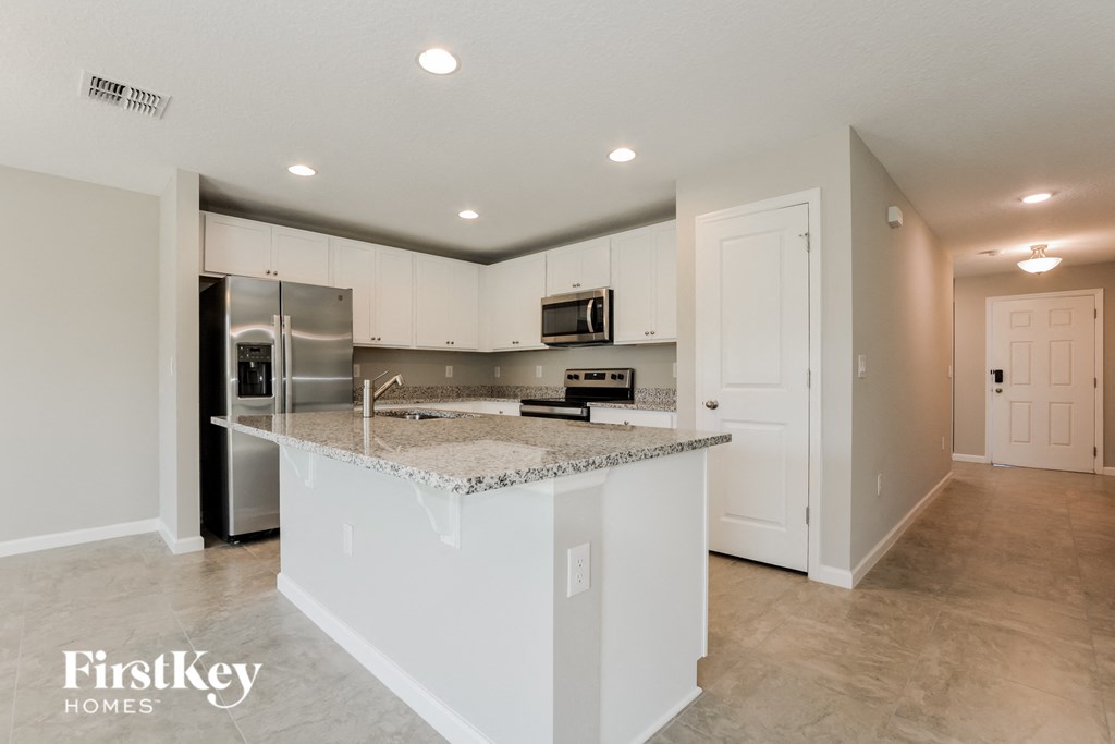 a kitchen with white cabinets and a granite counter top