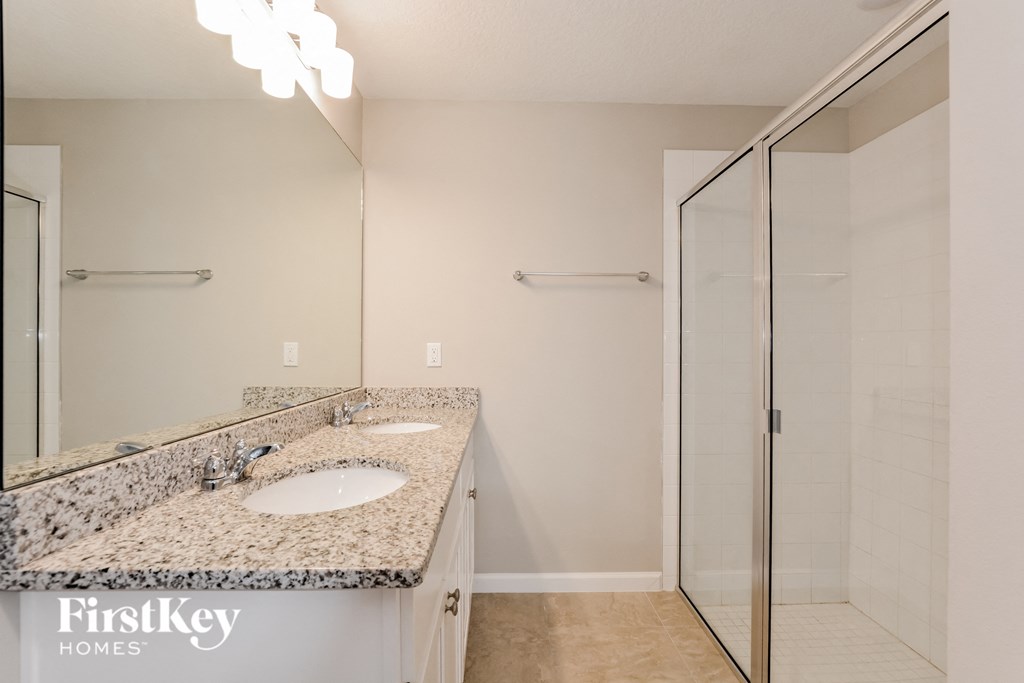 a bathroom with granite counter tops and a shower