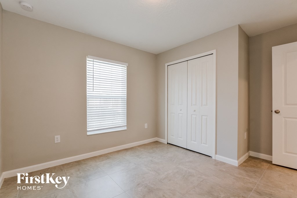 a bedroom with a closet and a door and a window