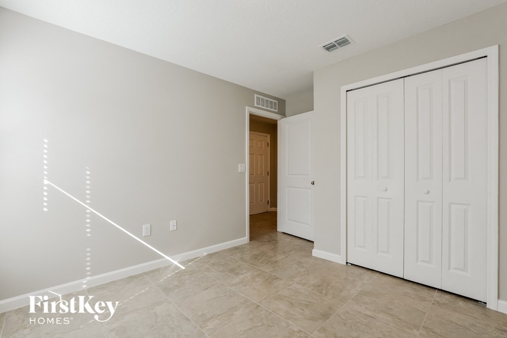 a master bedroom with two closets and a door to a hallway with a door