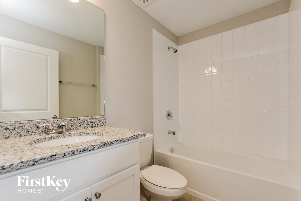 a white bathroom with a white toilet and tub and a sink