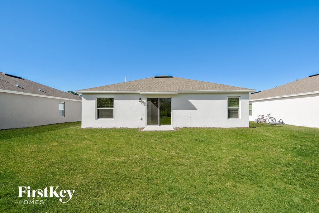 a white house with a green lawn and a blue sky
