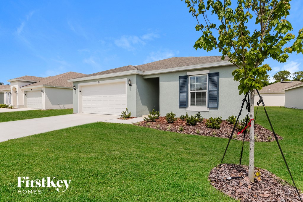 a home with a lawn and a tree