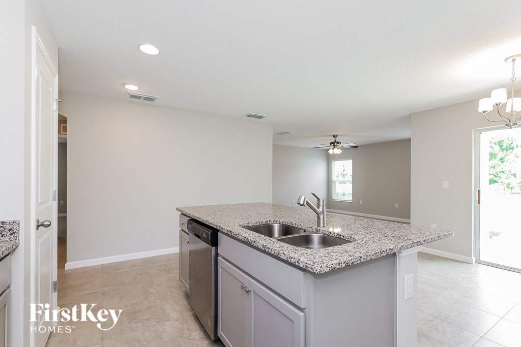 a kitchen with granite countertops and a stainless steel sink