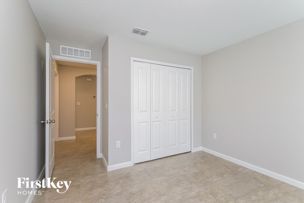 a bedroom with a closet and a door to a hallway