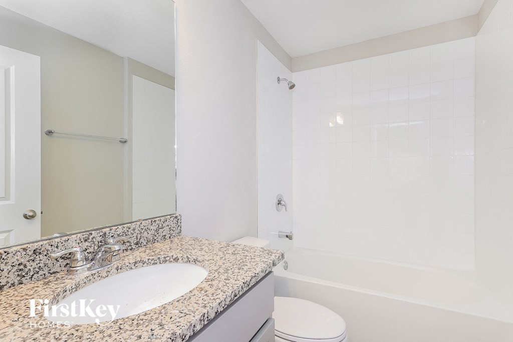 a bathroom with a sink and a shower and a toilet