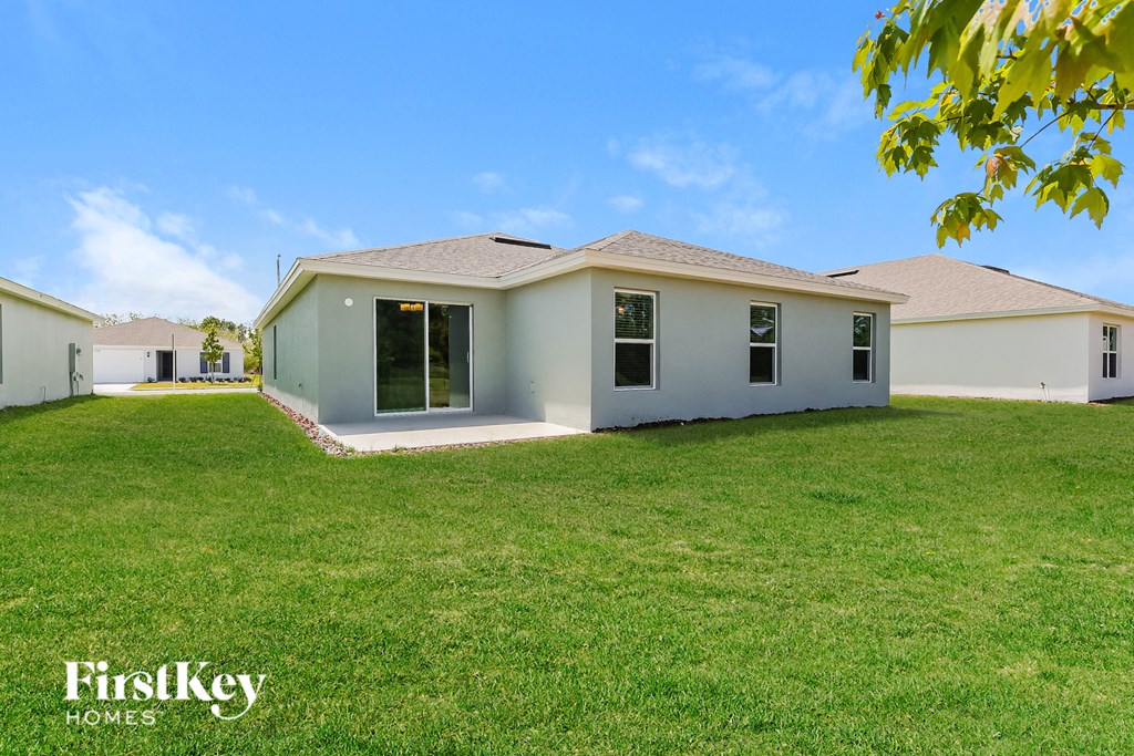 a white house with a green lawn and a blue sky