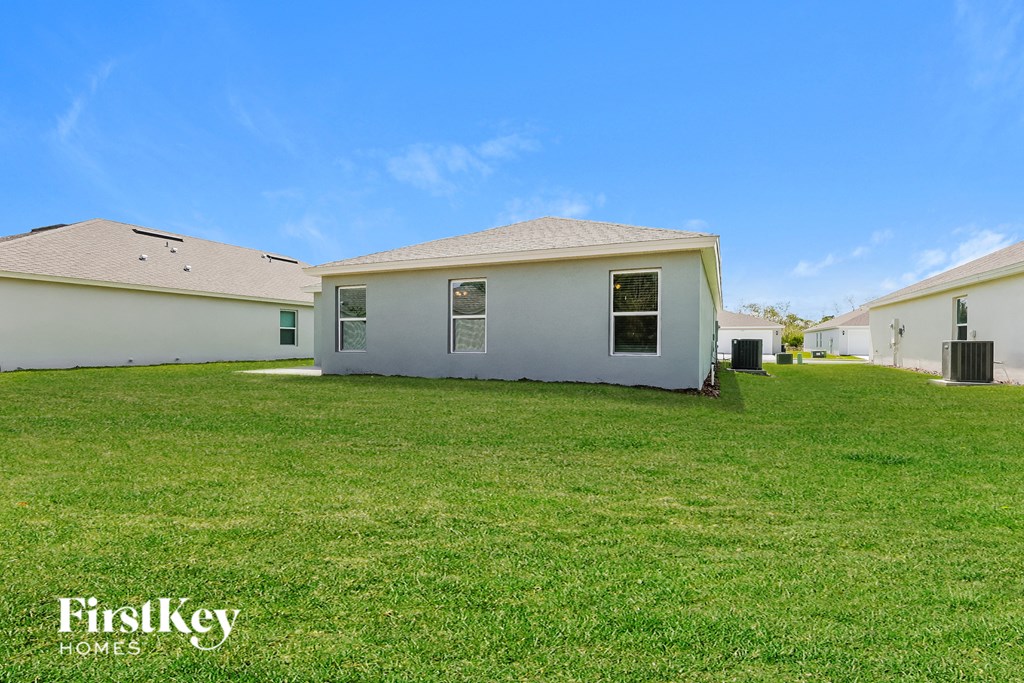 a white house with a green lawn and a blue sky