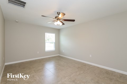 the spacious living room with ceiling fan and tile flooring
