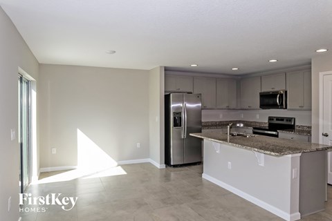 A kitchen with a granite countertop and stainless steel appliances.