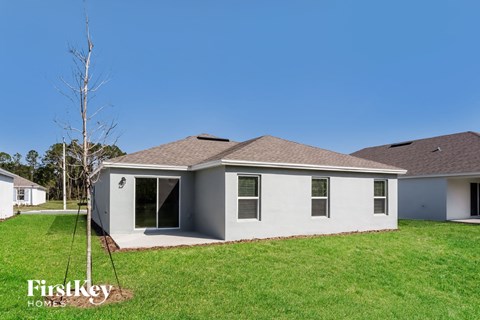 A house with a white exterior and a brown roof is shown.