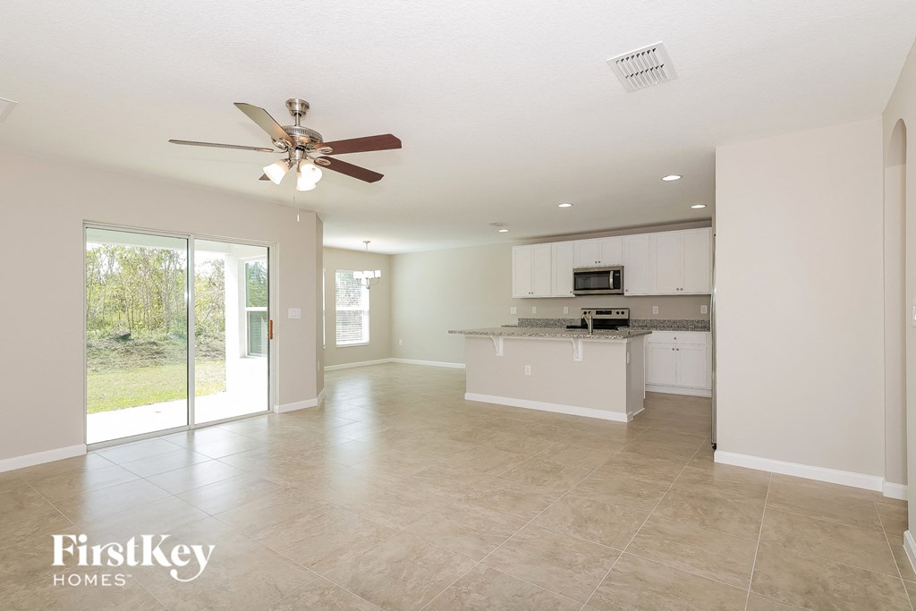 a kitchen and living room with a ceiling fan