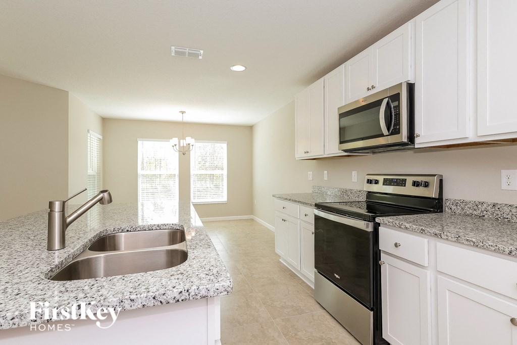 a kitchen with white cabinets and granite counter tops