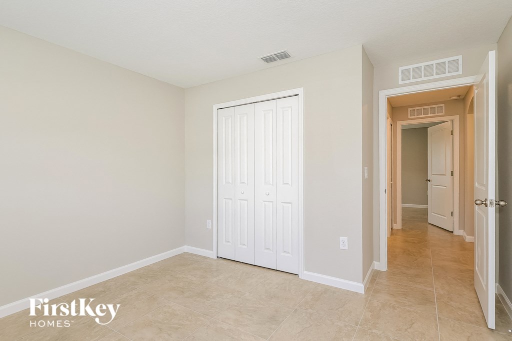 a bedroom with a closet and a door to a hallway