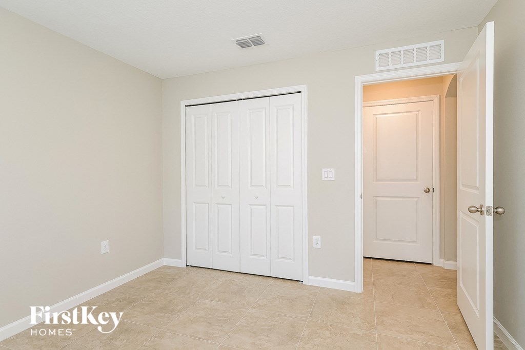 a bedroom with two closets and a door to a hallway