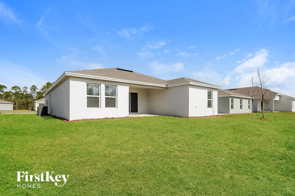a white house with a green lawn and a blue sky
