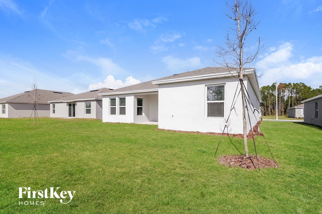 a white house with a tree in the yard