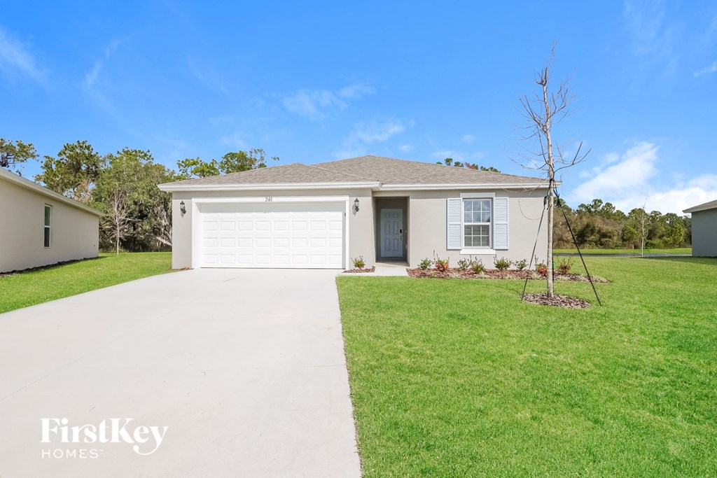 a white house with a driveway and a lawn