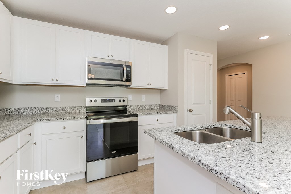 a kitchen with white cabinets and granite counter tops