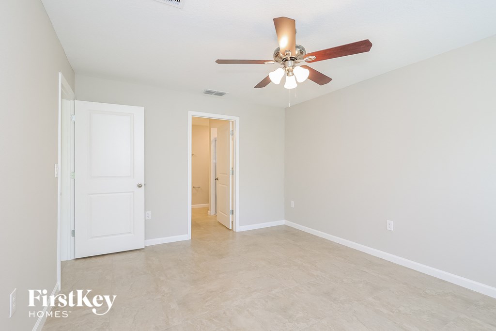 a clean and empty living room with a ceiling fan