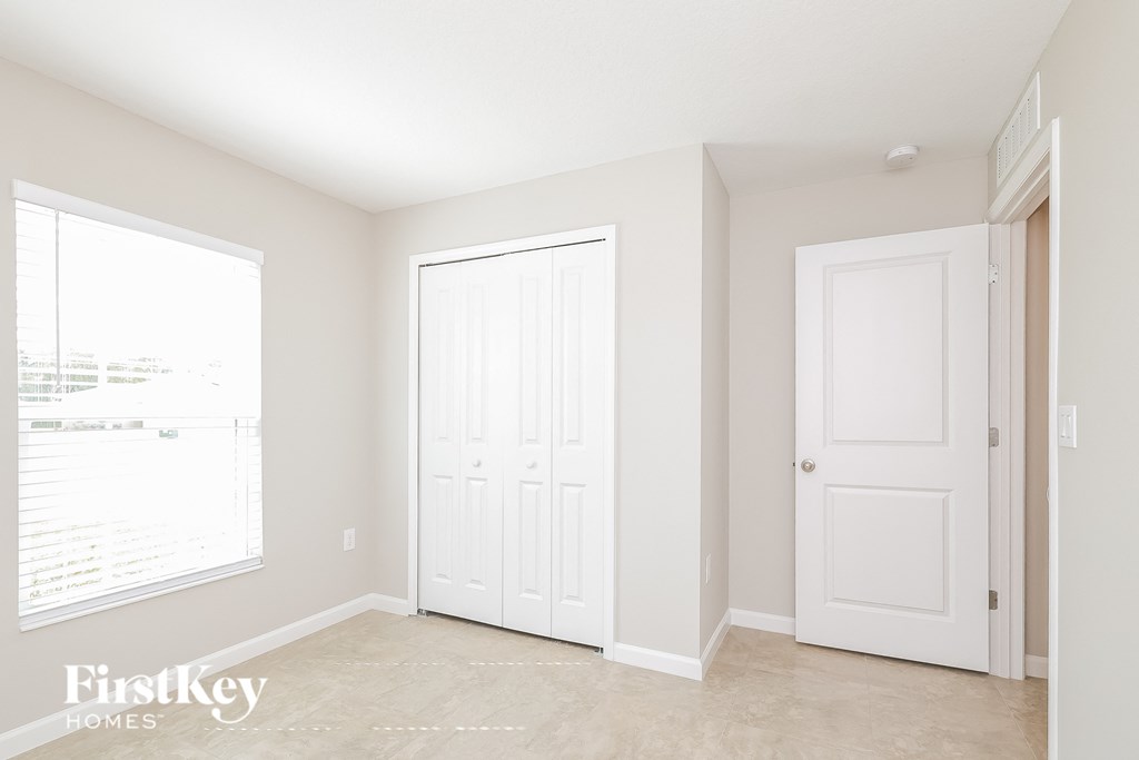 a bedroom with two white doors and a window