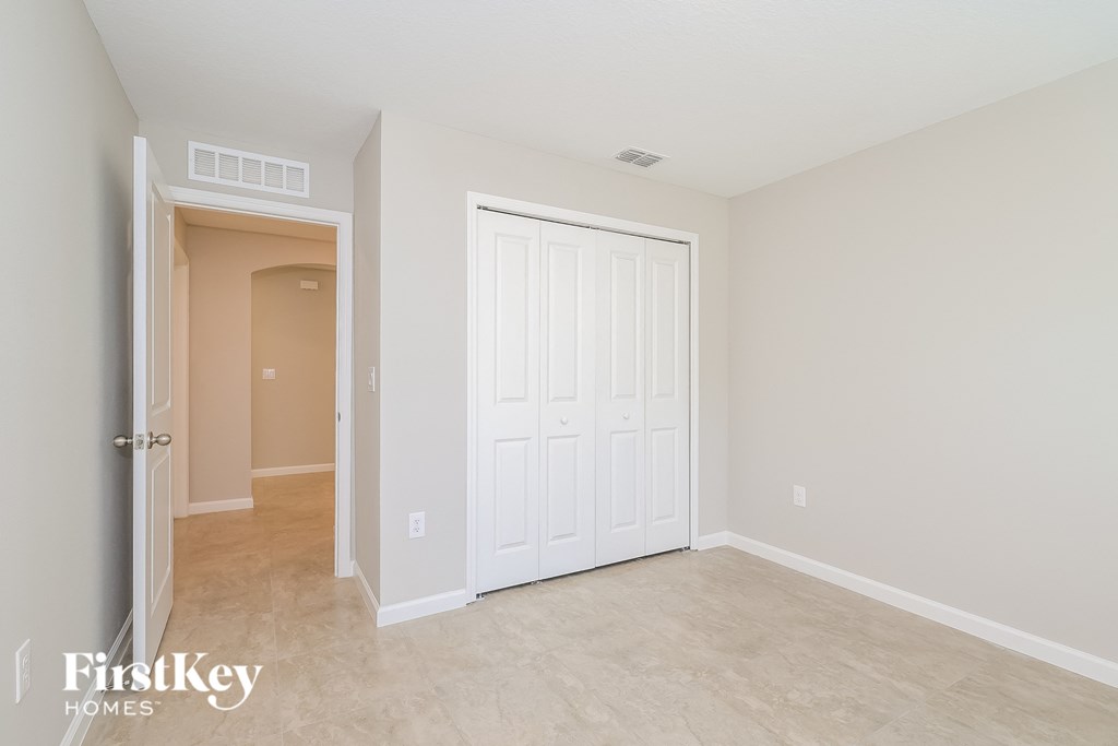 a bedroom with a closet and a door to a hallway