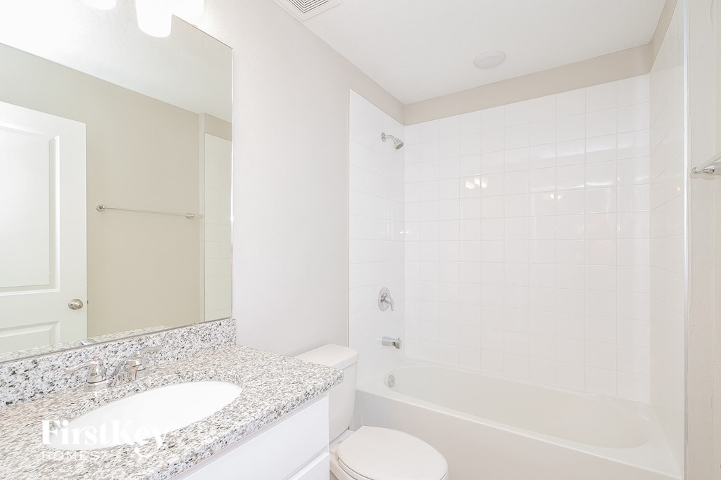 a bathroom with a sink and a shower and a toilet