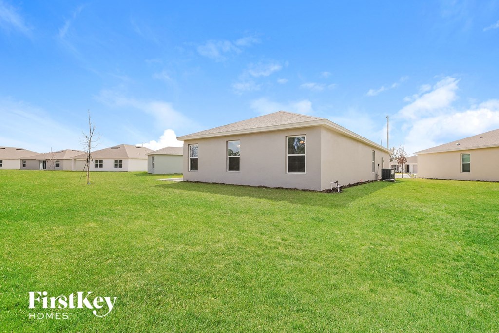 a backyard with a house and a green lawn