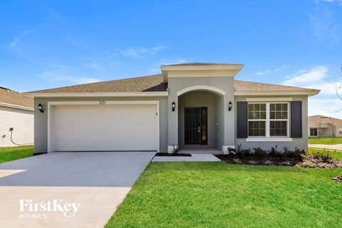 A house with a garage door and a driveway in front.