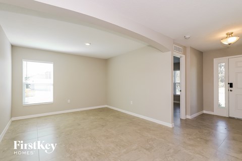A spacious empty room with a door on the right side.