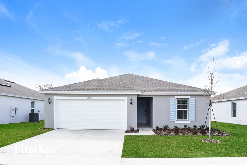 A house with a white garage door and a grey roof.
