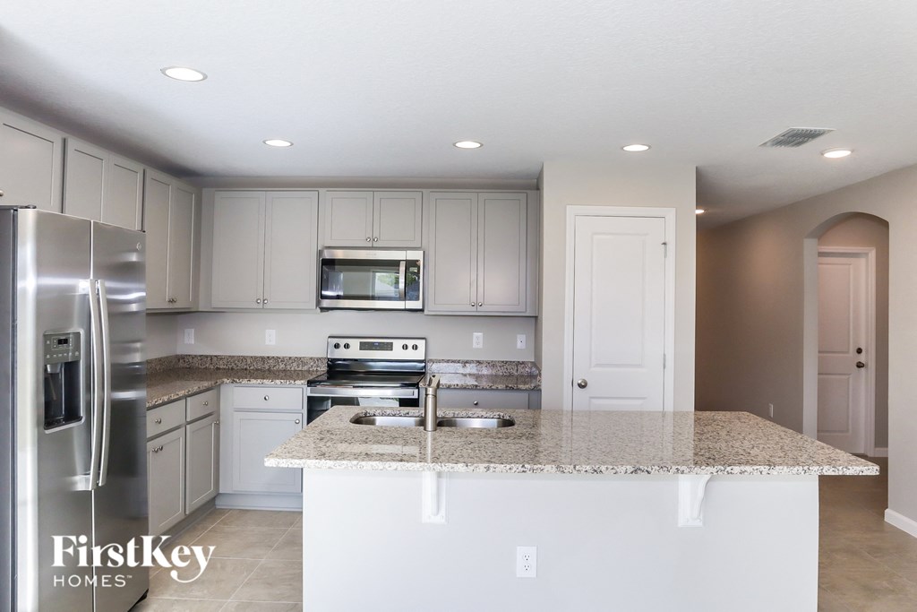 A kitchen with granite countertops and stainless steel appliances.