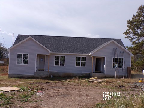 A house under construction with a grey roof and white walls.