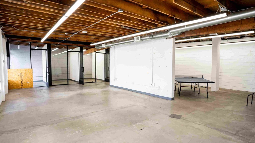 a large room with white walls and a table and chairs