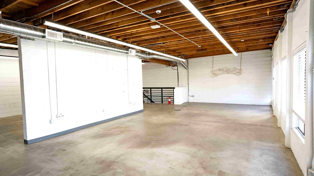 the inside of a warehouse with white walls and a concrete floor