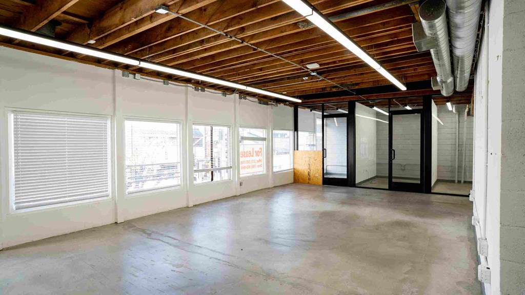 a large empty room with windows and a concrete floor
