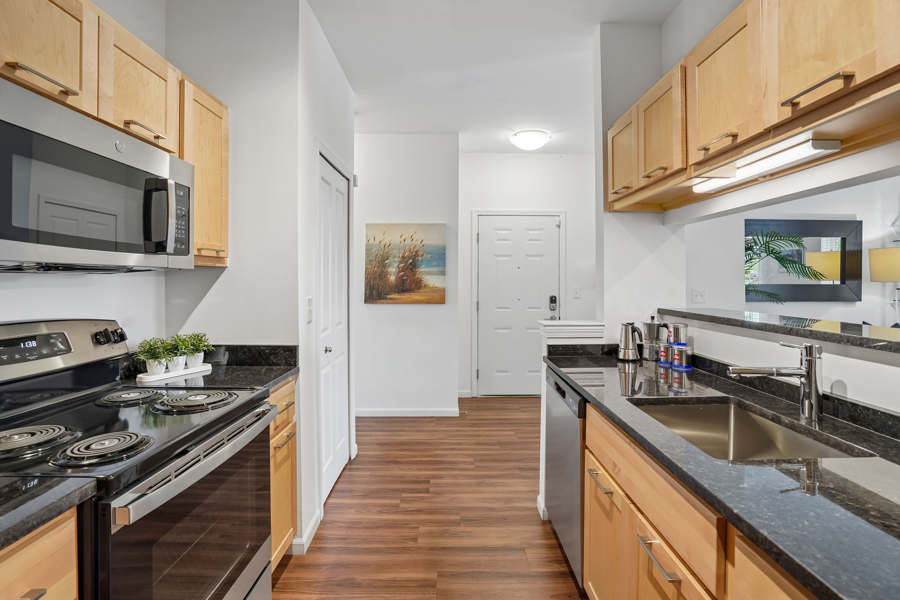 A kitchen with wooden cabinets and black countertops.
