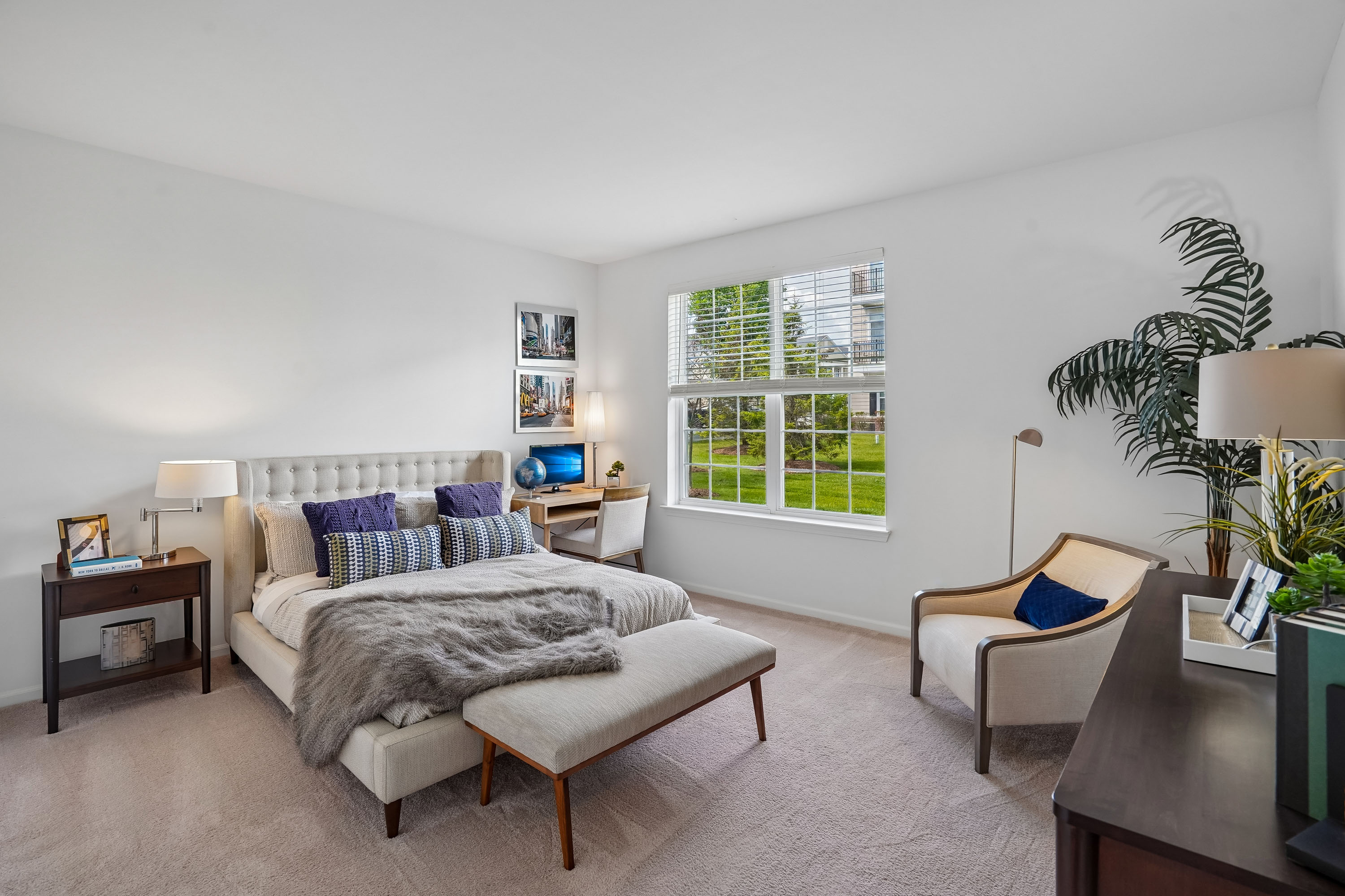 A bedroom with a large bed and a chair.
