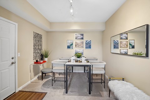 A dining room with a white table and chairs.