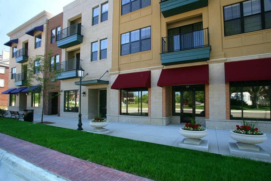 a row of buildings with red awnings and green grass